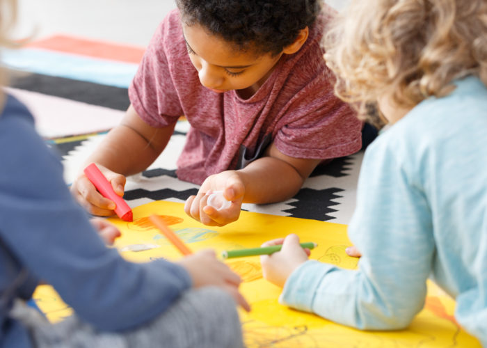 Close-up of kids drawing a picture in a group